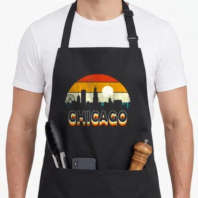 Tablier de cuisine noir avec illustration rétro du skyline de Chicago et une roue de manège au coucher du soleil.