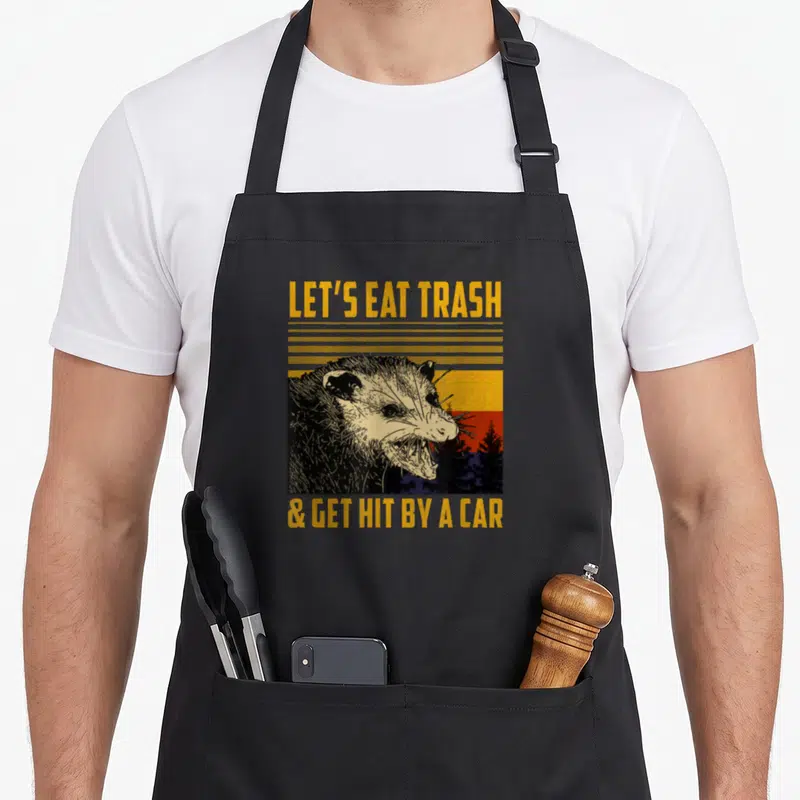 Tablier de cuisine noir avec illustration vintage d'opossum et texte jaune Let's Eat Trash & Get Hit By A Car.