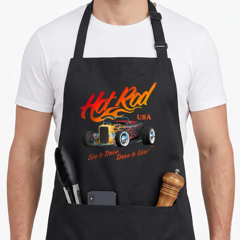 Tablier de cuisine noir avec illustration hotrod vintage, flammes orange et texte Hot Rod USA en lettrage stylisé.
