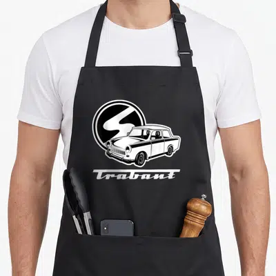 Tablier de cuisine noir avec illustration blanche d'une voiture Trabant 601 et le logo circulaire Trabi en arrière-plan.