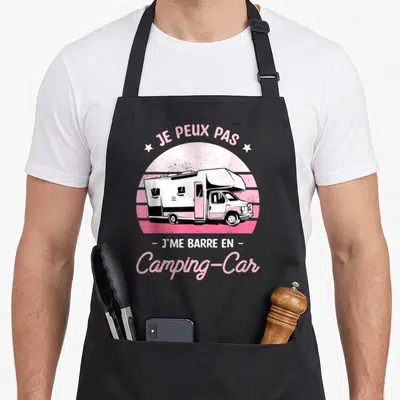 Tablier de cuisine noir avec une illustration de camping-car rose et blanc sous le texte Je peux pas j me barre en camping car campeur.