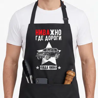 Tablier de cuisine noir avec illustration blanche d'un SUV Lada Niva sur une étoile et texte en alphabet cyrillique rouge et blanc.
