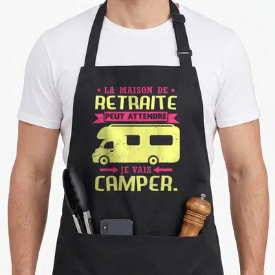 Tablier de cuisine noir avec illustration de camping-car jaune et texte humoristique sur la retraite.