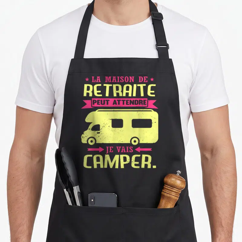 Tablier de cuisine noir avec illustration de camping-car jaune et texte humoristique sur la retraite.