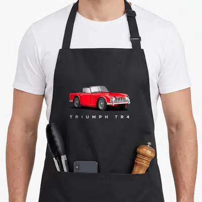 Tablier de cuisine noir avec illustration d'une Triumph TR4 rouge et du texte TRIUMPH TR4 en blanc.