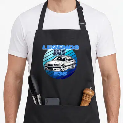 Tablier de cuisine noir avec illustration BMW E36 blanche et texte Legends Never Die sur fond bleu rayé.