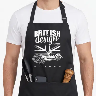 Tablier de cuisine noir avec illustration blanche d'une Morgan roadster et texte British design icons Morgan sur fond de drapeau Union Jack stylisé.