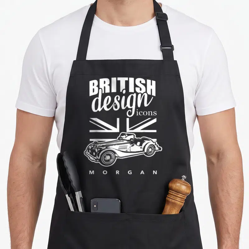 Tablier de cuisine noir avec illustration blanche d'une Morgan roadster et texte British design icons Morgan sur fond de drapeau Union Jack stylisé.