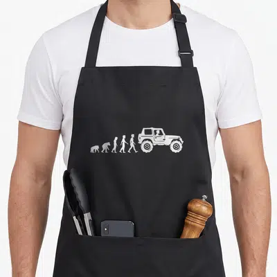 Tablier de cuisine noir avec illustration blanche montrant l'évolution de l'homme vers un véhicule tout-terrain 4x4.