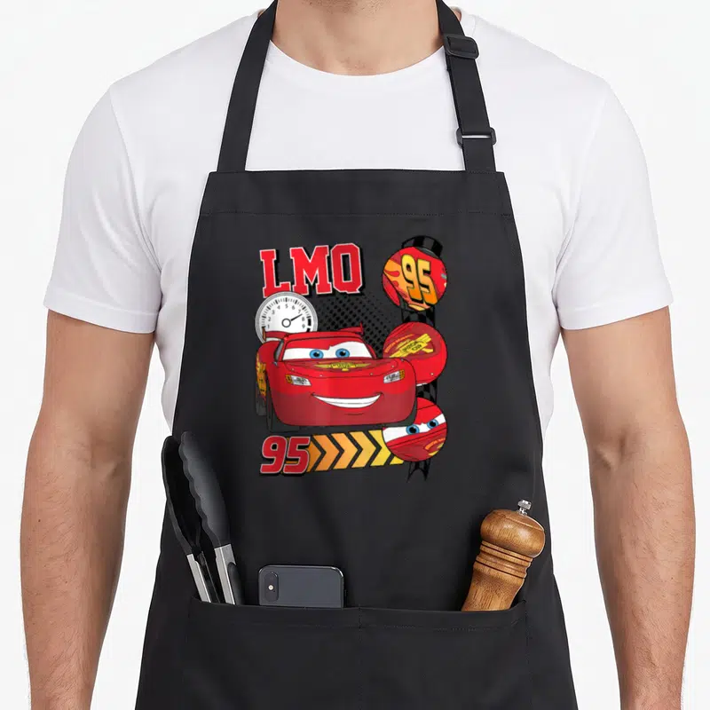 Tablier de cuisine noir avec illustration rouge du bolide LMQ 95, un compteur et des éléments graphiques de course.