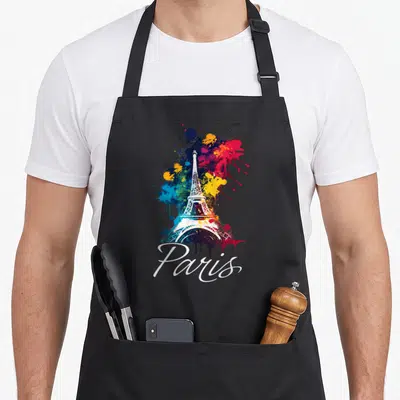 Tablier de cuisine noir avec une illustration colorée de la Tour Eiffel et le mot Paris en écriture cursive blanche.