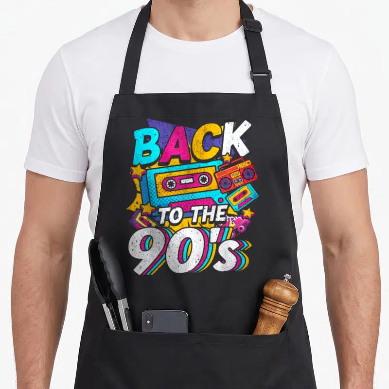 Tablier de cuisine noir avec illustration rétro Back to the 90's, cassette audio et boombox multicolores sur fond uni.