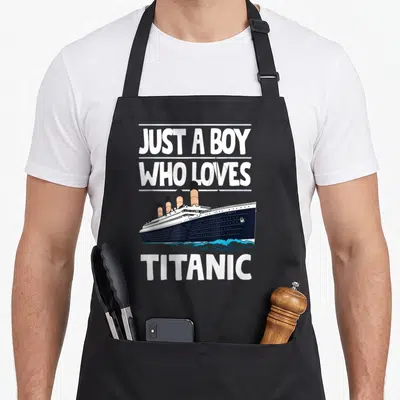 Tablier de cuisine noir avec illustration du navire Titanic et texte blanc Juste un garçon qui aime le Titanic.