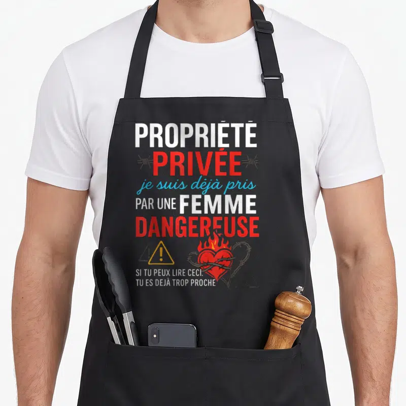 Tablier de cuisine noir avec inscription Propriété Privée Femme Dangereuse et cœur en barbelé.
