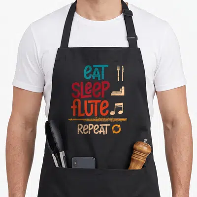 Tablier de cuisine noir avec inscription Mange Dors Flûte Répéte Flûte et icônes musicales colorées sur fond uni.