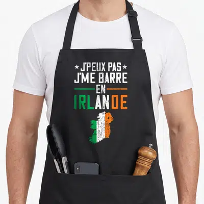 Tablier de cuisine noir avec inscription J'peux pas j'me barre en Irlande et silhouette du pays aux couleurs du drapeau.
