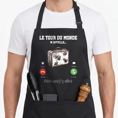 Tablier de cuisine noir avec une valise dessinée et les mots Le tour du monde m'appelle Faut que j'y aille.