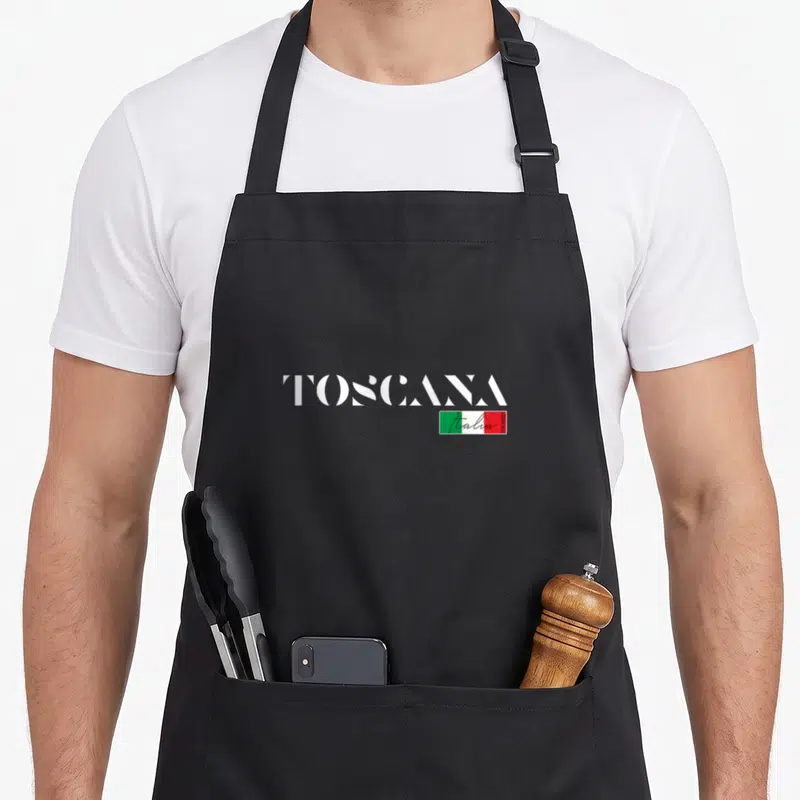 Tablier de cuisine noir avec inscription blanche Toscana Italia et petit drapeau italien coloré au centre.