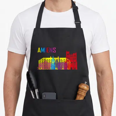 Tablier de cuisine noir avec skyline d'Amiens multicolore et inscription AMIENS en lettres vives.