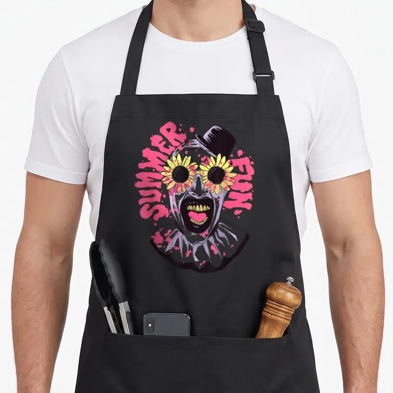 Tablier de cuisine noir avec un clown aux lunettes en fleurs et l'inscription Summer Fun en arrière-plan rose.