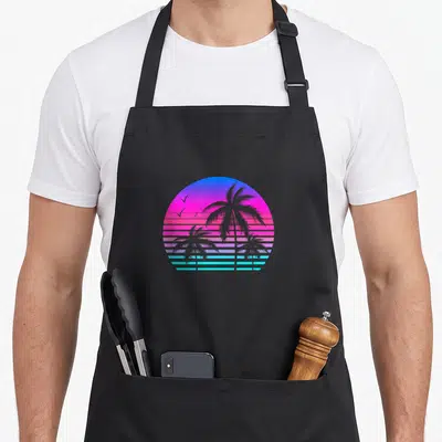 Tablier de cuisine noir avec illustration circulaire de palmiers sur fond dégradé rose bleu style vaporwave rétro.