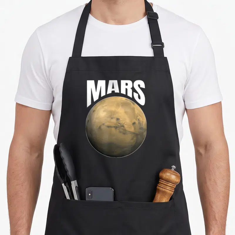 Tablier de cuisine noir avec une illustration circulaire de la planète Mars et le mot MARS en lettres blanches au-dessus.