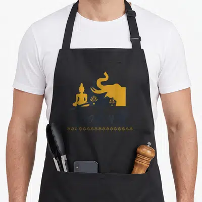 Tablier de cuisine noir avec illustration d'un éléphant, d'une statue de Bouddha et le mot Thaïland en lettres noires.