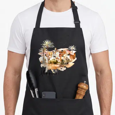 Tablier de cuisine noir avec illustration aquarelle du Maroc, palmiers et architecture traditionnelle sous le mot Morocco.