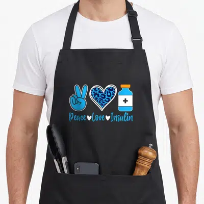 Tablier de cuisine noir avec main peace, cœur léopard bleu et flacon insuline sous le texte Peace Love Insulin.