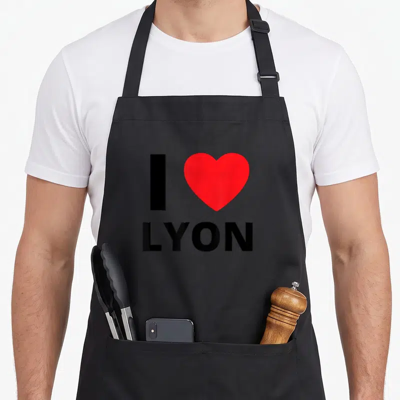 Tablier de cuisine noir avec inscription I Love Lyon et un grand cœur rouge au centre.