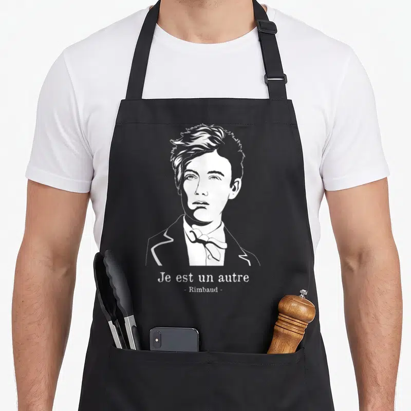 Tablier de cuisine noir avec portrait blanc de Rimbaud et la phrase Je est un autre imprimée en dessous.