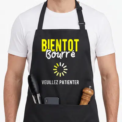 Tablier de cuisine noir avec l'inscription Bientot Bourre et un logo de chargement jaune.
