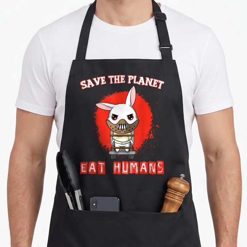 Tablier de cuisine noir avec un lapin blanc masqué sur fond rouge et texte Save the planet eat humans.