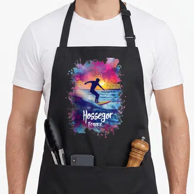 Tablier de cuisine noir avec silhouette de surfeur et inscription Hossegor France sur fond de couleurs vives.