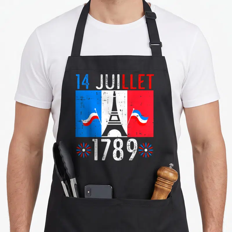 Tablier de cuisine noir avec drapeau français, tour Eiffel, texte 14 Juillet 1789 et feux d'artifice.