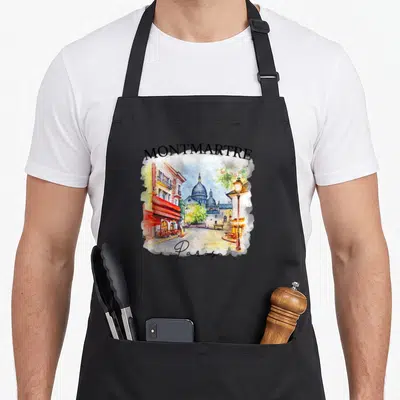 Tablier de cuisine noir avec une aquarelle colorée représentant Montmartre Paris Amour et ses cafés typiques.