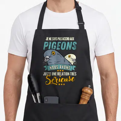 Tablier de cuisine noir avec illustration de deux pigeons et texte humoristique sur la relation sérieuse avec les oiseaux.