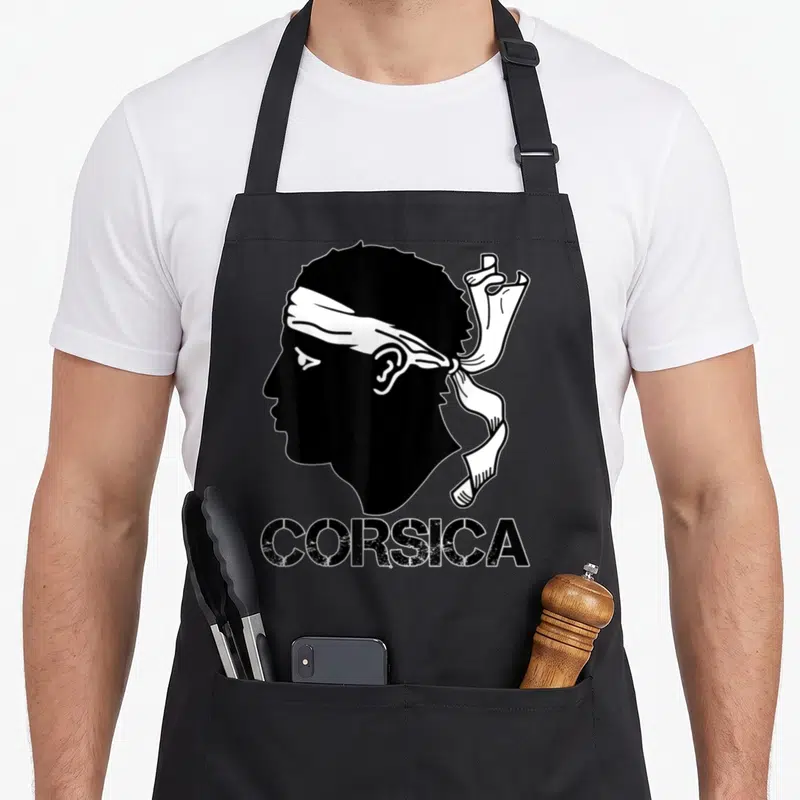 Tablier de cuisine noir avec silhouette tête de Maure et inscription CORSICA en bas.