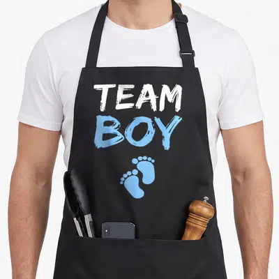 Tablier de cuisine noir avec inscription Team Boy en blanc et bleu et deux petits pieds imprimés.