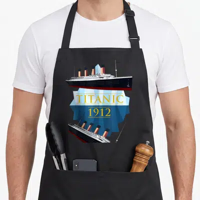 Tablier de cuisine noir avec illustration du Titanic 1912 et iceberg bleu géométrique au centre.