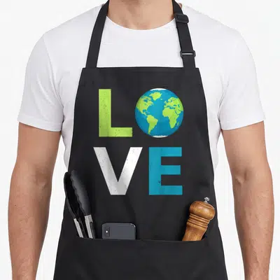 Tablier de cuisine noir avec le mot LOVE où O est un globe terrestre bleu et vert.