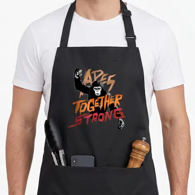 Tablier de cuisine noir avec illustration d'un gorille et texte Apes Together Strong en orange et rouge.