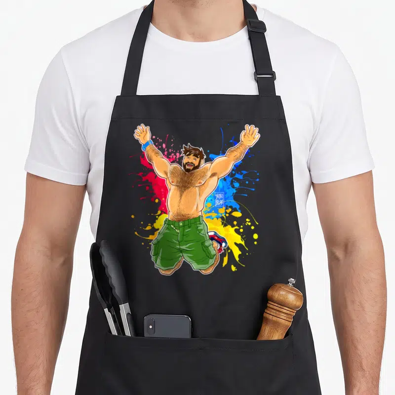 Tablier de cuisine noir avec illustration d'un homme musclé en shorts verts sautant les bras levés sur fond d'éclaboussures colorées.