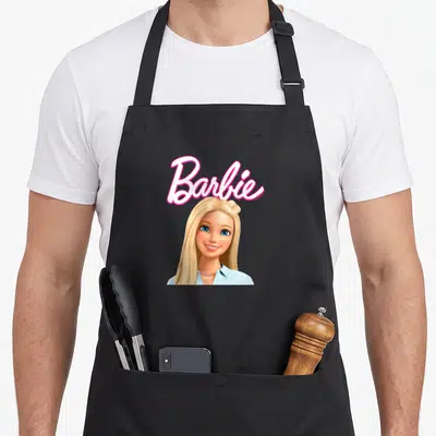 Tablier de cuisine noir avec illustration tête souriante Barbie et logo script rose