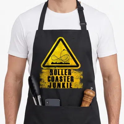 Tablier de cuisine noir avec panneau jaune montagnes russes et texte Roller Coaster Junkie en noir.