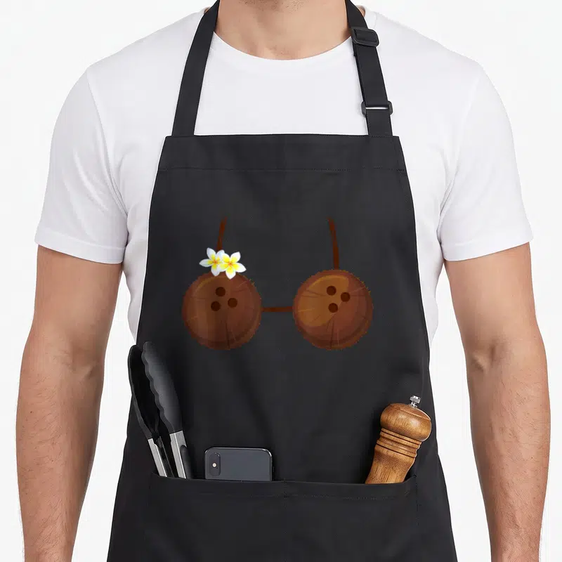 Tablier de cuisine noir avec un soutien-gorge hawaïen en noix de coco orné de fleurs blanches et jaunes.