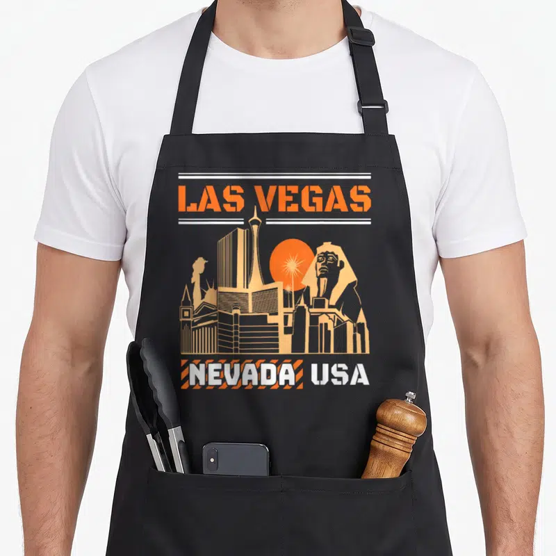 Tablier de cuisine noir avec illustration orange du skyline de Las Vegas Nevada USA incluant Sphinx et Stratosphere Tower.