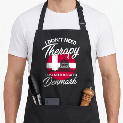 Tablier de cuisine noir avec inscription I Don't Need Therapy sur fond de drapeau danois et silhouette architecturale.