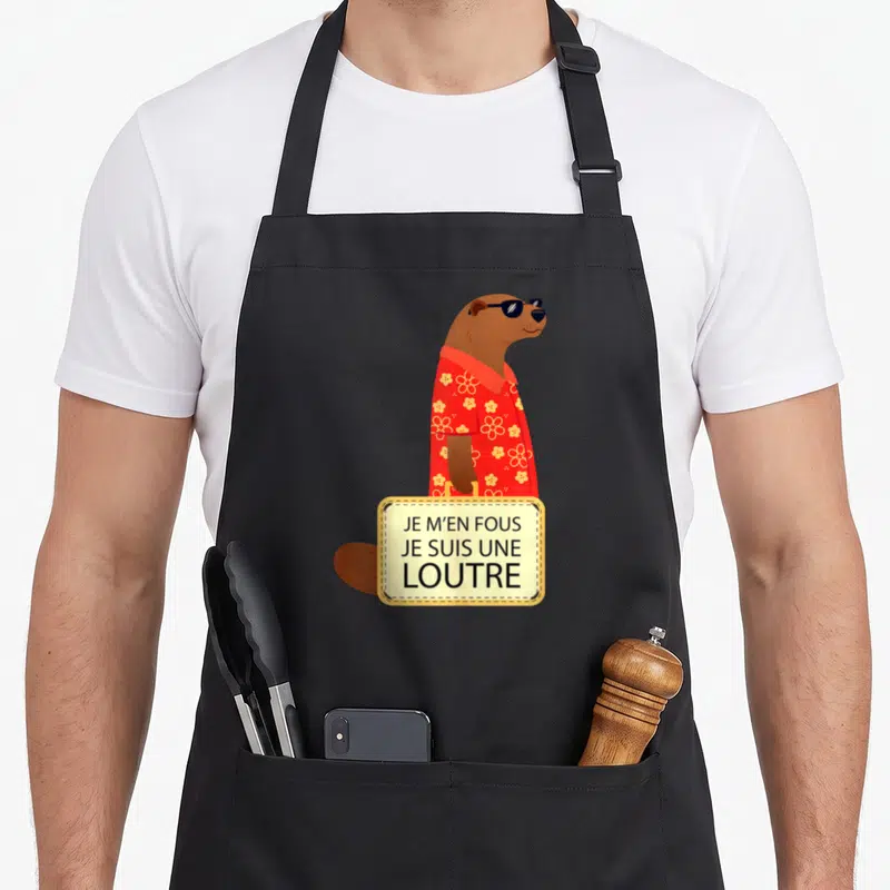 Tablier de cuisine noir avec une loutre en chemise rouge portant des lunettes noires et tenant une valise avec du texte imprimé.