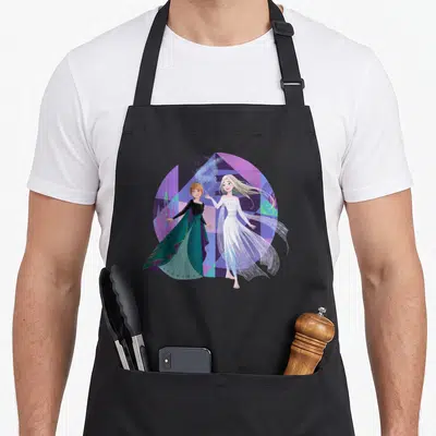 Tablier de cuisine noir avec Anna et la Reine des Neiges Elsa sur fond géométrique violet et vert.